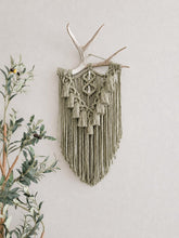 Load image into Gallery viewer, green macrame wall hanging on an antler
